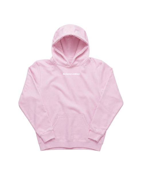 A light pink pullover hoodie with a small white 'the journey continues' text logo on the chest, displayed flat against a solid white background.