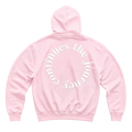 A light pink pullover hoodie shown from the back, featuring the phrase 'the journey Continues' printed in white curved text across the upper back.